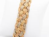 braided bracelet with gold and silver beads on a white pillow