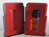 un petit flacon de parfum dans une boîte rouge