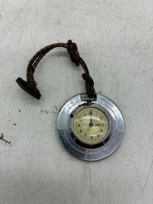 une petite horloge accrochée sur le bord d'une table