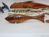 many different types of wooden fish on the table