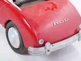 a red toy car that is sitting on a white surface