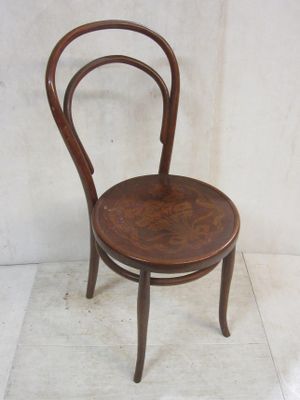 a small wooden chair with a bent back and a wooden seat