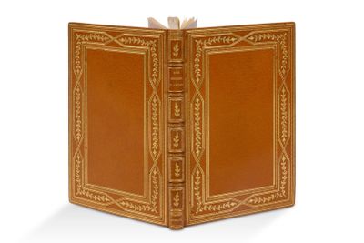 un vieux livre à la couverture brune posé sur une surface blanche