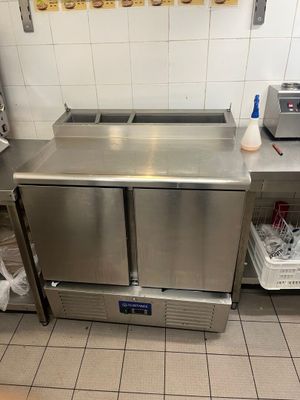 un plan de travail en inox équipé de deux éviers et d'un grille-pain