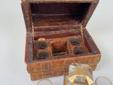a small wooden box with several glasses inside of it