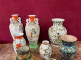 plusieurs vases posés sur une table, avec un mur rouge en arrière-plan