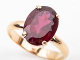 a close up of a ring with a red stone in it