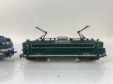 two toy trains sitting side by side on a white surface