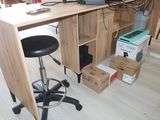 a desk with a laptop on it and a stool in front of it