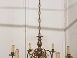 un lustre ancien en laiton à cinq branches et cinq bougies