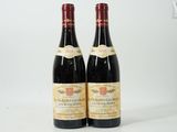 deux bouteilles de vin posées l'une à côté de l'autre sur une surface blanche