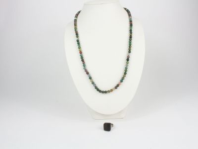un gros plan d'un collier porté par un mannequin, orné d'une perle noire