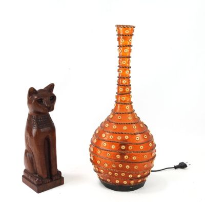 un chat et un vase posés l'un à côté de l'autre sur une table