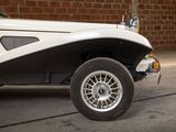a white and black car parked in front of a brick wall