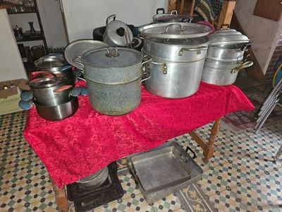 pots and pans on a table in a kitchen with a red table cloth