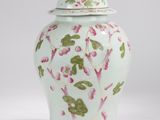 un vase vert et rose avec un couvercle sur fond blanc