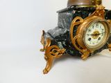 une horloge posée sur un bloc de marbre