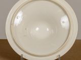 a white plate on a stand on a table