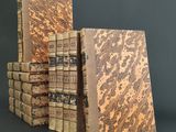 several old books stacked on top of each other on a table