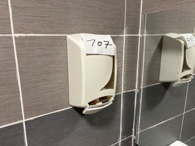 deux distributeurs de savon fixés au mur de la salle de bains