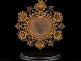 an image of a gold plate with a medallion on top of it