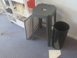 a trash can sitting next to a stool in a room