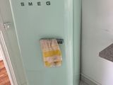 a blue refrigerator with a towel hanging on the door
