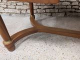 a wooden table with a marble top on a stone floor