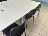 a white table and black chairs in a room with blue walls