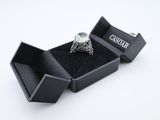 a diamond ring in a black box on a white surface