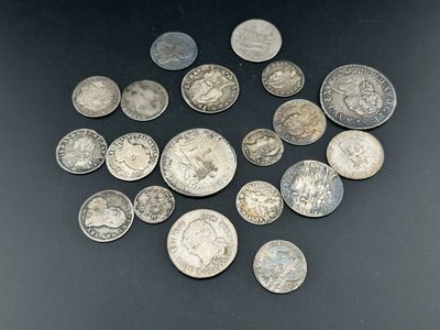 quelques pièces d'argent sont éparpillées sur une surface noire