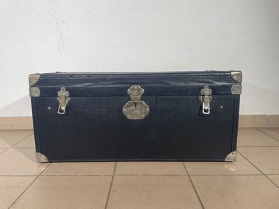 a black trunk sitting on the floor in a room