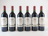 six bouteilles de vin sont alignées sur une table