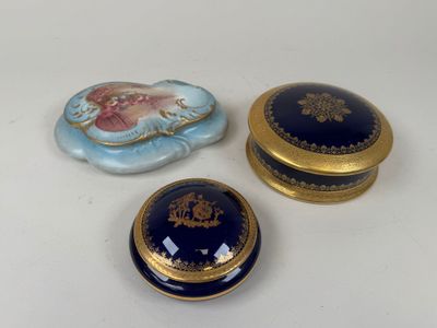three small blue and gold boxes sitting on top of a white table