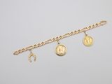 a gold bracelet with charms and a coin on it
