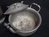 a silver pot with a lid sitting on a black surface