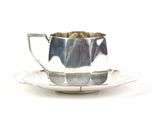 une tasse et une soucoupe en argent posées sur une soucoupe