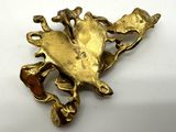 gold plated broochle with a frog on it ' s back