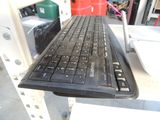 a black keyboard sitting on top of a white table