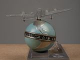 a model of a plane that is sitting on top of a globe