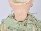 a doll with a green shirt and a green scarf