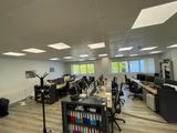 une salle où se trouvent de nombreux bureaux et chaises