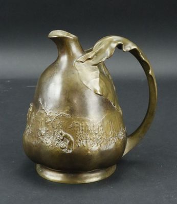 cruche en bronze ornée d'un oiseau sur fond noir