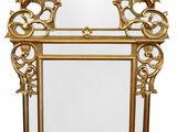 an ornate gold framed mirror with an ornate design