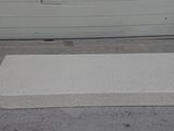 a mattress on the ground in front of a garage door