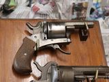 two revolvers that are sitting on top of a wooden table