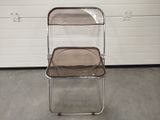 a clear plastic chair with a brown seat in front of a garage door