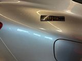 a close up of a silver car with a sticker on it