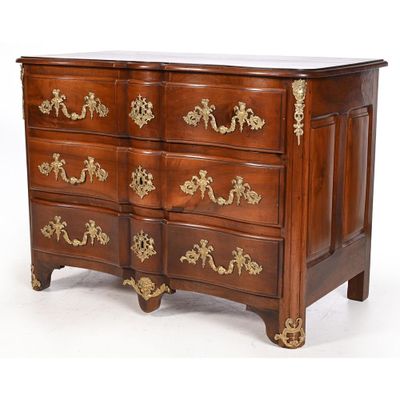 a wooden chest of drawers with gold decorations on it