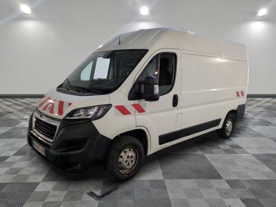 la camionnette blanche est garée sur un sol carrelé en damier